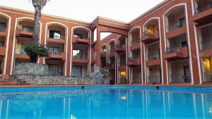 a hotel with a swimming pool in front of a building at Hotel Hacienda Cola del Caballo in Santiago +32 photos