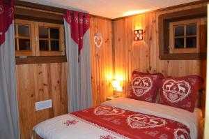 クソンリュプト・ロンジュメールにあるRev2chaletのベッドルーム1室(赤と白の枕が備わるベッド1台付)