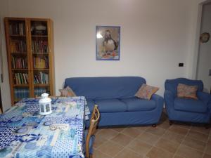 ein Wohnzimmer mit einem blauen Sofa und einem Tisch in der Unterkunft Casetta al Mare in Giustenice