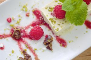 a piece of cake with raspberries and mint on a plate at The Lamb Inn in Bourton on the Water
