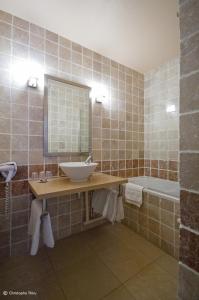 a bathroom with a sink and a mirror and a tub at Hôtel-Restaurant La Mandia in La Mongie