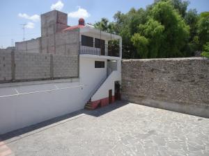 a building with a balcony and a brick wall at Hotel San Isidro in Bernal