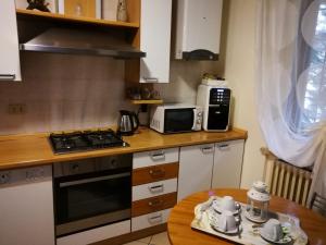 a kitchen with a stove top oven next to a table at B&B Covidafranciacorta in Castrezatto