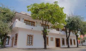 ein weißes Gebäude mit Bäumen davor in der Unterkunft Hotel La Casa de las Cocadas in San-Blas-Inseln
