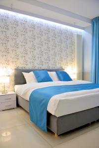 sypialnia z dużym łóżkiem i niebieskim kocem w obiekcie JessApart – Ochota Apartments w Warszawie