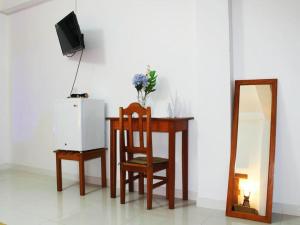 a table with a chair and a tv and a mirror at Hotel Rulman in Puerto Maldonado
