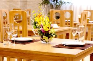 una mesa con vasos y un jarrón de flores. en Gia Vien Hotel, en Ho Chi Minh