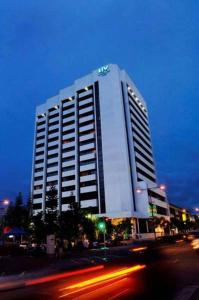 - un grand bâtiment blanc dans une rue de la ville la nuit dans l'établissement Harbour View Hotel, à Kuching