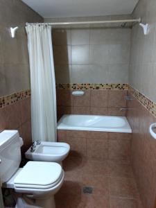 a bathroom with a toilet and a tub and a sink at Altos del Boulevard in Santiago del Estero +26 photos