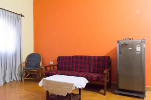 a living room with a couch and a refrigerator at Villa Emmanuel 1BHk Holiday Homes in Candolim