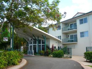 a large white building with a tree in front of it at Koala Court Holiday Apartments in Cairns