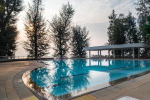 a large swimming pool with a building in the background at Sandy Beach Condo 17D in Cha Am