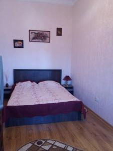 a bedroom with a bed and a table with a lamp at Apartment on Zarvanskaya in Old Town in Kamianets-Podilskyi