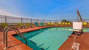 a swimming pool with chairs and a fence at Best Western Plus/Executive Residency Elk City in Elk City