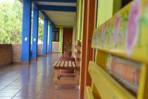 un pasillo de una escuela con un banco y vigas azules en Hotel Quetzalcalli, en San Juan Teotihuacán