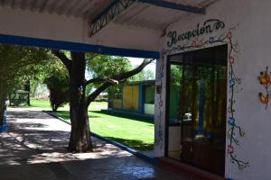 una entrada a un edificio con un árbol delante en Hotel Quetzalcalli, en San Juan Teotihuacán
