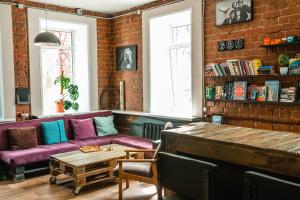 a living room with a purple couch and a brick wall at Montana hostel in Irkutsk