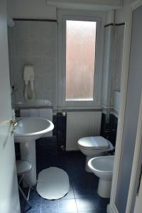 a bathroom with two toilets and a sink and a window at Hotel Il Gatto in Rapallo
