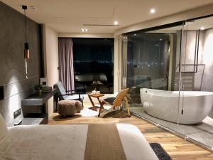 a bathroom with a large tub and a bedroom at Something Easy Inn in Jiufen