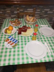 a green and white table with plates of food on it at Hostal Casa Tino in Caín