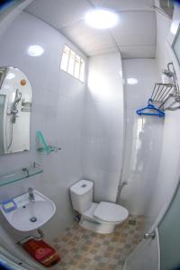 a white bathroom with a toilet and a sink at SƠN THỊNH Guesthouse in Ho Chi Minh City