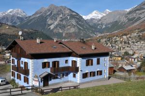 duży dom z górami w tle w obiekcie Hotel Eira w mieście Bormio