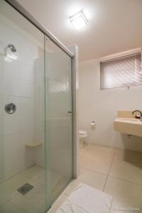 a bathroom with a glass shower and a sink at Aruá Hotel, Restaurante e Convenções in Presidente Prudente