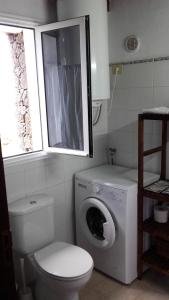 een badkamer met een toilet en een wasmachine bij Dos Violetas in Mocanal