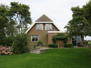 a house with a green yard with a house at Wide ie Grou in Nes