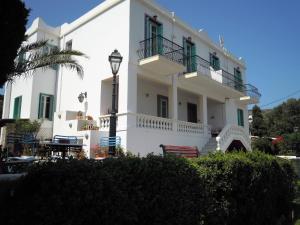 a white house with a balcony and a street light at Blue Dolphin in Batsi