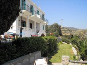 a white house with a balcony on a hill at Blue Dolphin in Batsi