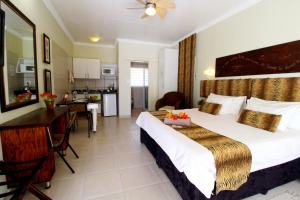 a hotel room with a bed and a kitchen at Wilger Guesthouse in Centurion +40 photos