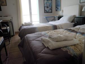 a hotel room with two beds with towels on the bench at Blue Dolphin in Batsi