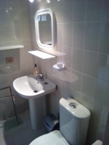 a bathroom with a toilet and a sink and a mirror at Caleta Paraiso - Lovely Coastal Apartment in Costa de Antigua