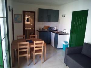 uma cozinha com mesa e cadeiras e uma cozinha com micro-ondas em Caleta Paraiso - Lovely Coastal Apartment em Costa de Antigua