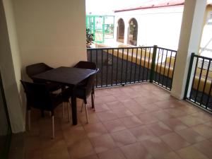 uma varanda com uma mesa preta e cadeiras e uma varanda em Caleta Paraiso - Lovely Coastal Apartment em Costa de Antigua