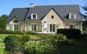 ein Haus mit einer Statue im Vorgarten in der Unterkunft Chambre Melody in Janville