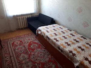 1 dormitorio con cama, alfombra y ventana en Apartment on Gagarina 2, en Zlatoust