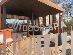 a sign for a outdoor grill on a wooden deck at Hostellerie du Peiffeschof, The Originals Relais (Relais du Silence) in Arlon