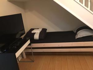 a bed in a room with a staircase with a television at Waltham Abbey Private Property in Waltham Abbey