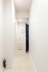 un pasillo con paredes blancas y una puerta negra en Cavour 51, en Lecco