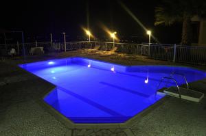 una piscina illuminata di notte in blu di Ionian Balcony a Lixouri