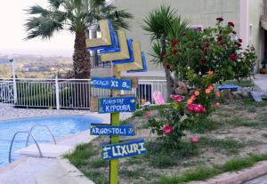 a sign with street signs in front of a pool at Ionian Balcony in Lixouri