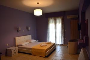 a bedroom with a bed and a large window at Ionian Balcony in Lixouri
