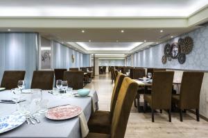 a dining room with tables and chairs and a room with at Hotel El Acebo in Jaca