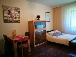 Un pequeño dormitorio con una cama y una mesa. en Apartament 10 Poranek - Pod Aniołem, en Kazimierz Dolny