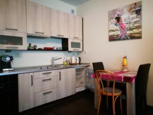 Una cocina con gabinetes blancos y una mesa con sillas. en Apartament 10 Poranek - Pod Aniołem, en Kazimierz Dolny