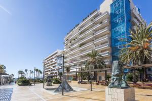 a large building with a statue in front of it at Apartamento Marbella Centro Av. del Mar in Marbella