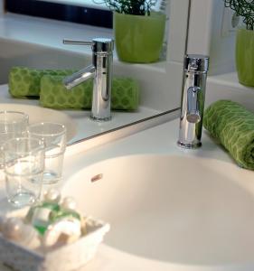 um lavatório de casa de banho com dois copos e uma torneira em Hotel zum See garni em Dießen am Ammersee