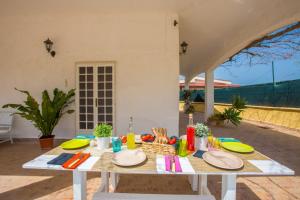 un tavolo bianco con piatti su un patio di Casa Mediterranea dei Normanni a San Vito dei Normanni